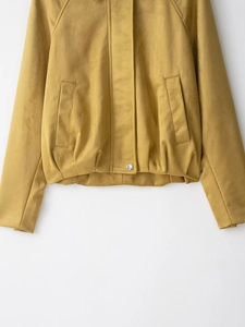 Detailed close-up of ginger yellow suede jacket featuring zipper and silver metal button