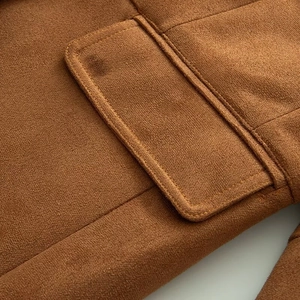 Detail of camel brown faux suede blazer showing flap pocket and premium stitching