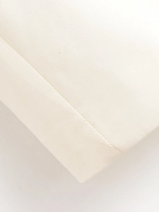 Détail de la texture tissée blanche et des coutures précises sur le revers