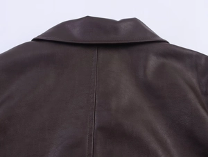Dettaglio del colletto della giacca in pelle marrone scuro e cuciture fini sul retro