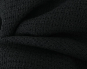 Macro shot of the black waffle weave fabric texture on the casual stand collar jacket
