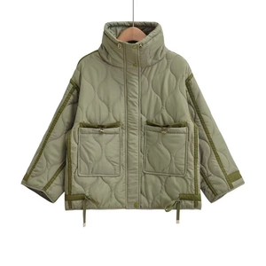Close-up of olive green quilted jacket featuring high collar and drawstring pocket details