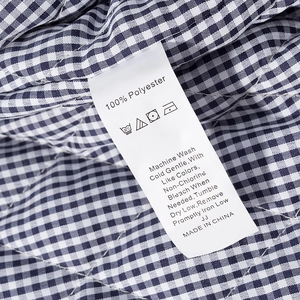 Detail of care label on 100% polyester blue and white gingham quilted jacket