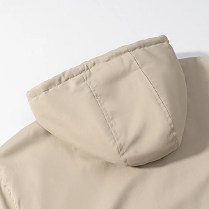 Detail view of the stitching and hood texture on light khaki reversible padded jacket