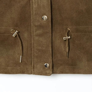 Gros plan d'une veste en daim marron avec col montant et boutons pression dorés