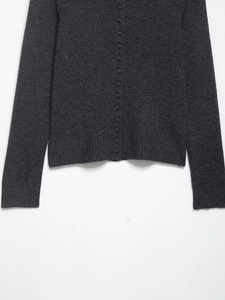 Detail of dark grey knit cardigan showing fur effect fabric and matching covered buttons