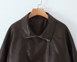 Detail of dark brown PU jacket featuring lapel collar with smooth silver metal zippers