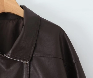 Close-up of deep brown PU leather jacket with wide lapels and silver metal zipper detail