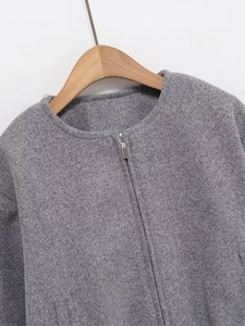 Close-up of grey textured faux-tweed jacket with silver zipper and round neckline