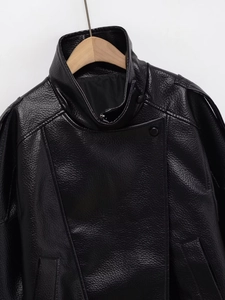 Détail de la veste noire en PU avec texture grainée et col asymétrique élégant