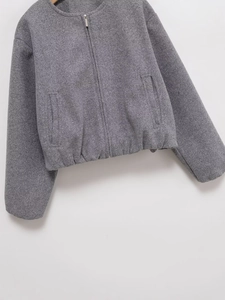 Detail of grey textured wool-like zip-up jacket with elastic hem and side pockets