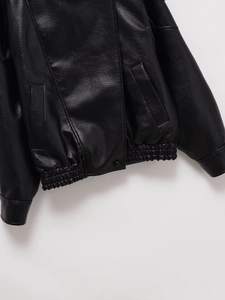 Détail de l'ourlet élastique et des poches latérales d'une veste en similicuir noir