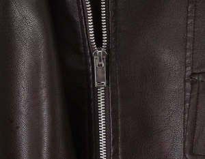 Close-up of the silver metal zipper and textured dark brown faux leather jacket detail
