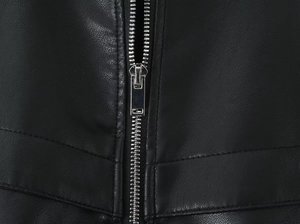 Détail de la fermeture éclair en métal argenté et surpiqûres sur veste en similicuir noir