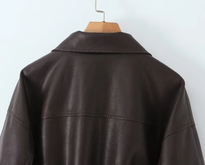 Detail view of the back collar and shoulder stitching on a dark brown PU leather jacket