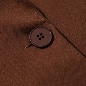 Detailed close-up of brown suit jacket fabric and premium four-hole resin button detail