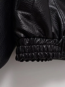 Vue détaillée de l'ourlet élastique d'une veste en similicuir noir de haute qualité