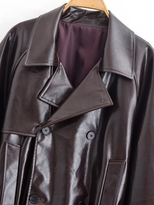 Detailed close-up of dark brown PU leather jacket featuring lapels and double-breasted buttons