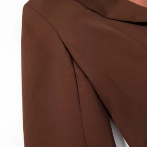 Detailed close-up of dark brown blazer lapel stitching and woven fabric texture