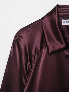 Close-up of the turn-down collar and satin texture on a burgundy women's baseball jacket