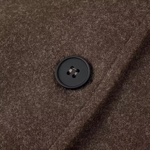 Vue détaillée du bouton noir et texture du tissu en laine mélangée marron foncé