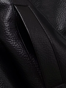 Détail de la texture en cuir PU noir avec coutures précises sur une veste de baseball
