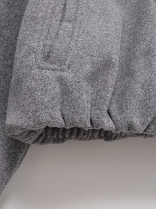 Close-up of grey soft tweed jacket showing elastic cuffs and premium stitching detail
