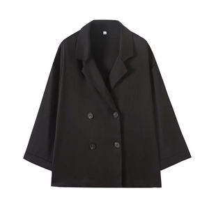 Detail of black double-breasted blazer with pleated texture and stylish notch lapel
