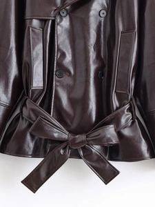 Detail of dark brown PU leather jacket featuring double-breasted buttons and tied waist belt