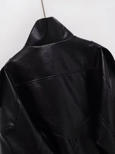Gros plan détaillé sur la texture du cuir PU noir et les coutures du col de la veste