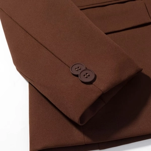 Detailed close-up of dark brown blazer cuffs with two matching matte buttons