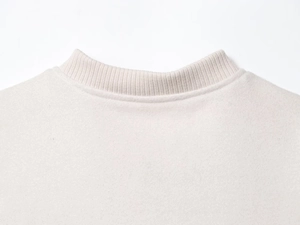 Detail of oatmeal ribbed crew neck collar and soft textured fabric on a baseball jacket
