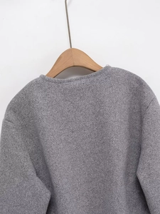 Macro view of grey textured wool-like fabric and round neckline on a baseball jacket