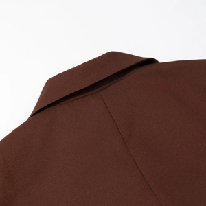Detail of a deep chocolate brown notched lapel and collar on a tailored suit jacket