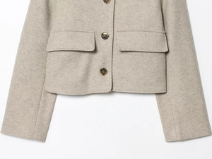 Detailaufnahme der beigen Wollmischjacke mit Hornknöpfen und aufgesetzten Taschen
