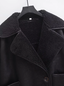 Detail of black faux shearling lining and matte suede finish on winter jacket