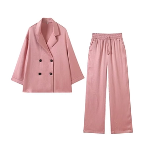 Detail of pink double-breasted blazer set with drawstring waist and textured fabric