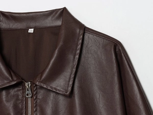 Gros plan de l'étiquette de taille XS sur une veste en similicuir marron avec fermeture