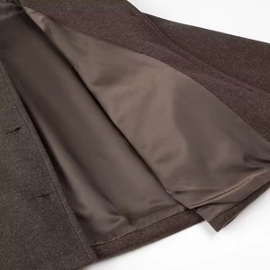 Détail du tissu en laine épaisse avec doublure en satin lisse et coutures précises