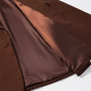 Detail view of deep brown blazer featuring heavy texture fabric and smooth satin lining
