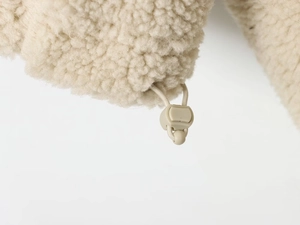 Vue détaillée de la texture polaire sherpa crème avec cordon de serrage réglable à l'ourlet