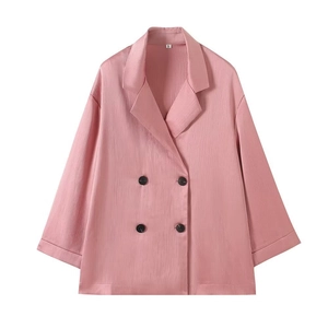 Detail of pink oversized blazer showing unique pleated texture and double-breasted buttons