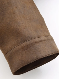 Gros plan détaillé de l'ourlet d'une veste en daim marron avec double couture