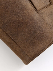 Gros plan sur la matière suédée marron de la veste avec coutures et texture de qualité