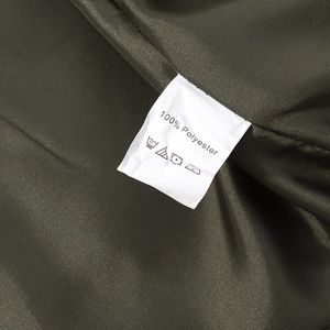 Detail shot of the 100% polyester fabric texture and care label on this green jacket