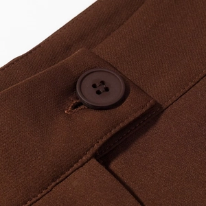 Detail view of the brown suit trousers waistband with a matching four-hole button