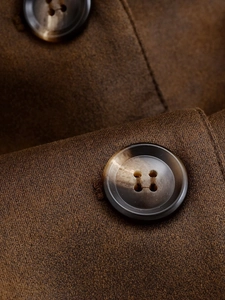 Détail d'une veste en laine marron avec boutons à quatre trous au fini ambré rétro