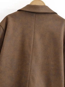 Détail du dos d'une veste en daim marron avec coutures verticales et une finition vintage