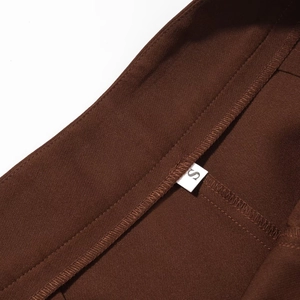 Detail shot of the size S label stitched inside dark brown woven suit trousers waist