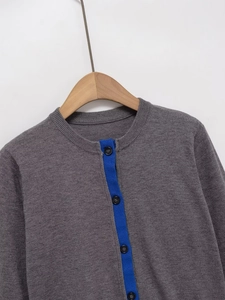 Close-up of dark grey knit cardigan with a contrasting bright blue button placket